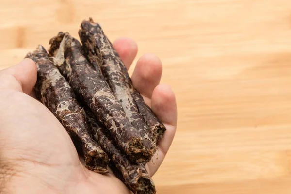 Person holding biltong sticks with a blurred background — 스톡 사진
