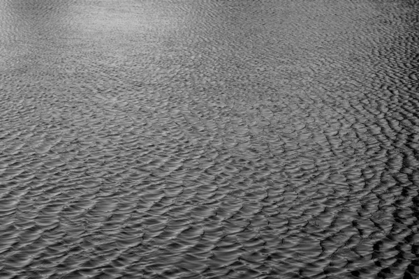 Grayscale disparou de um mar com ondas pequenas — Fotografia de Stock