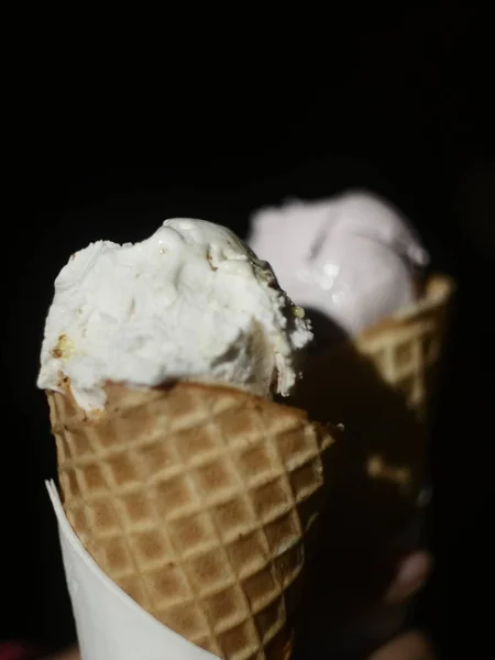 Vertical shot of a two delicious ice cream cones with a black background — Stock Photo, Image