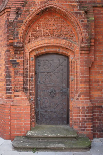 Foto vertical de un antiguo edificio misterioso con puerta metálica. — Foto de Stock