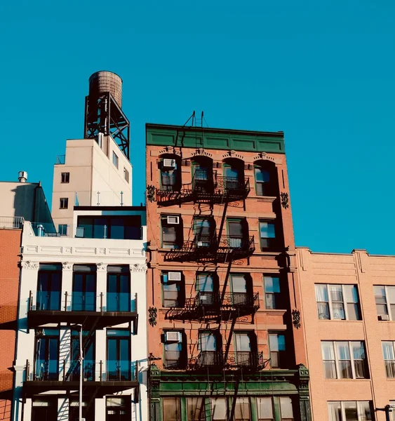 Verticale opname van een appartement met trap naar brandtrap en een blauwe lucht op de achtergrond — Stockfoto