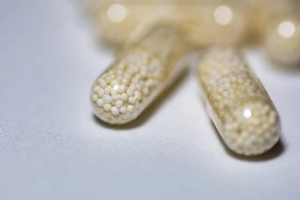 Closeup shot of capsules on a white surface — Stock Photo, Image