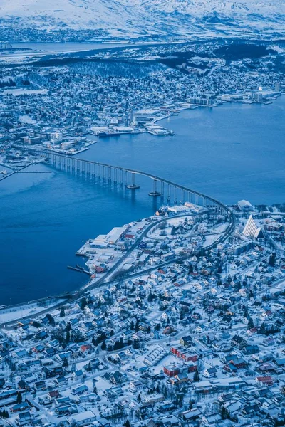 Foto aérea vertical de la hermosa ciudad de Tromso cubierta de nieve capturada en Noruega — Foto de Stock