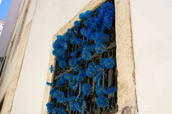 Низкоугольный Снимок Синих Бумажных Цветов Украшающих Окно — стоковое фото