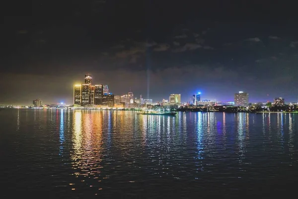 Licht van de verlichte gebouwen weerkaatst in het donkere water 's nachts — Stockfoto