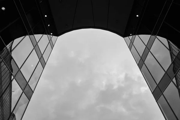 Eine Graustufenaufnahme Der Spiegelfenster Eines Modernen Gebäudes Und Des Wolkenverhangenen — Stockfoto