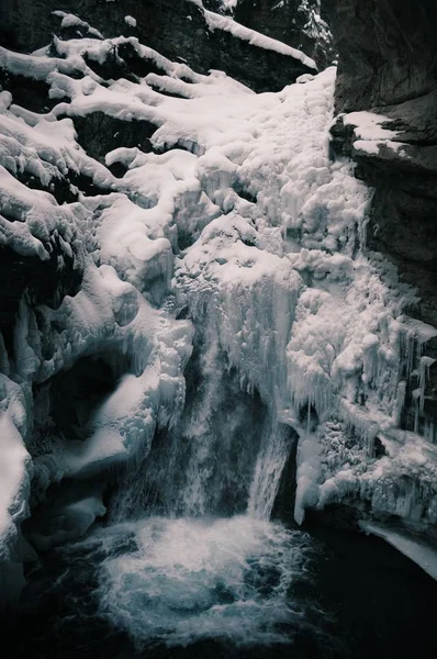 冬の岩に囲まれた凍る滝の垂直ショット — ストック写真