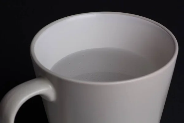 Eine Hochwinkelaufnahme Einer Tasse Warmen Wassers Vor Schwarzem Hintergrund — Stockfoto