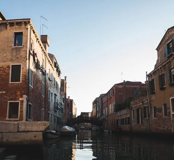 Kanaal in het midden van gebouwen met een brug over het water in de verte in Venetië Italië — Stockfoto