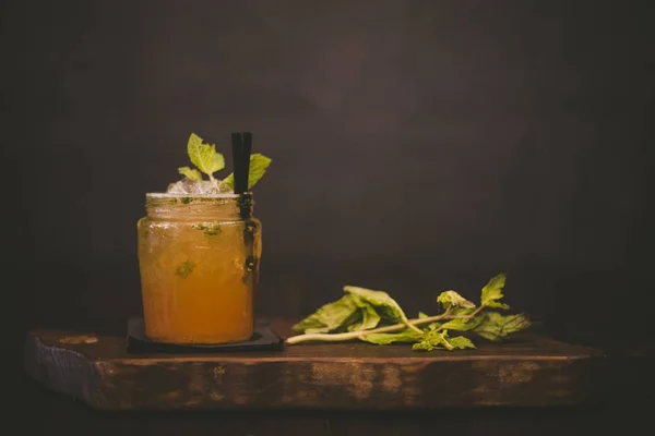 Orange drink with black straws and a mint leaf — 스톡 사진