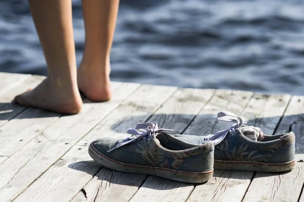 Босоногий Стоящий Рядом Грязной Обувью Пристани Моря — стоковое фото