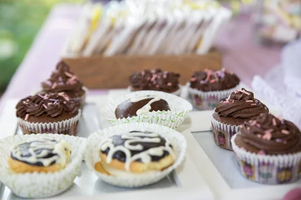 Closeup of chocolate cupcakes on the table under the lights with a blurred background — Stok fotoğraf