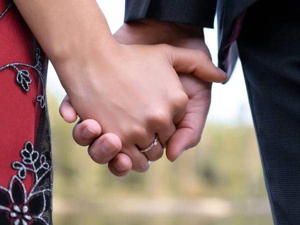 Nahaufnahme eines Paares, das sich mit einem Verlobungsring an den Händen hält - Liebeskonzept — Stockfoto