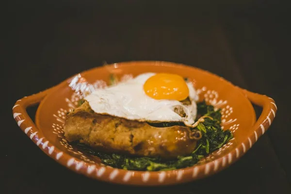 Primer plano de un plato con huevo, salchichas y hojas de verduras —  Fotos de Stock