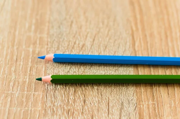 Een Close Van Twee Blauwe Groene Potloden Een Houten Ondergrond — Stockfoto