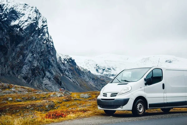 White van on the road surrounded by rocks covered in the snow — 스톡 사진