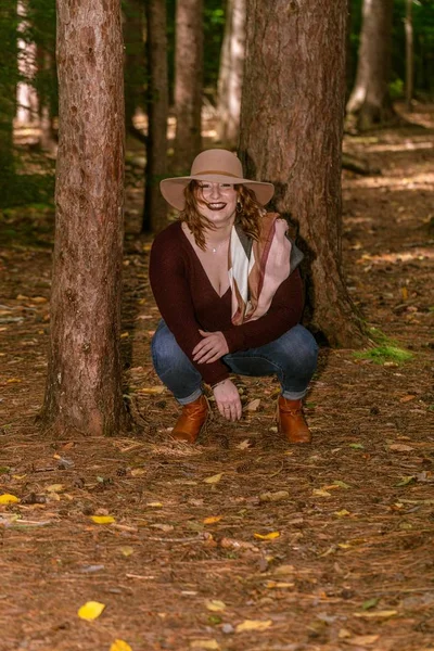 Kvinna Med Röd Blus Och Hatt Poserar Skog Omgiven Träd — Stockfoto