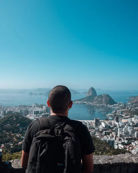 建築と海とブラジルの美しい景色を楽しむバックパックを持つ男性 — ストック写真