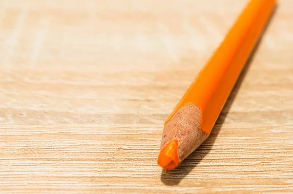 Eine Nahaufnahme Eines Orangefarbenen Bleistifts Auf Einer Holzoberfläche — Stockfoto