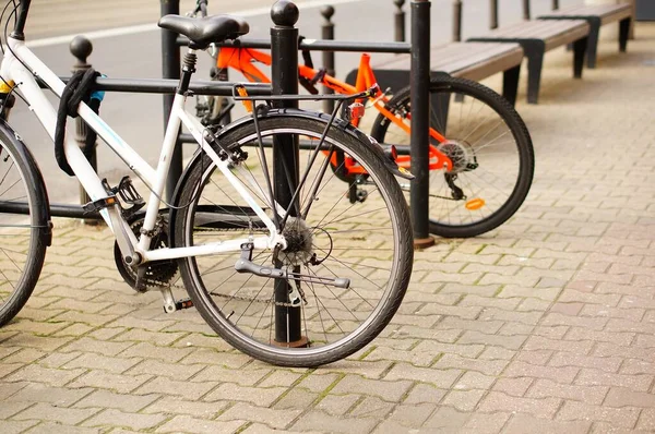 Baixo ângulo close-up tiro de duas bicicletas estacionadas na calçada — Fotografia de Stock