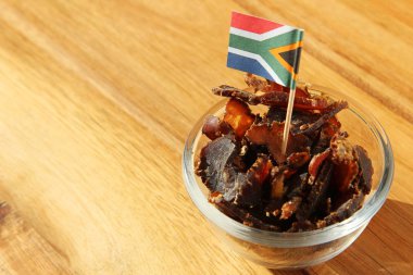 The flag of South America on traditional biltong snack on a wooden surface clipart