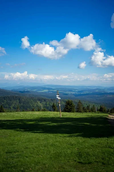Prise de vue d'un panneau contre un paysage d'arbres et de collines — Photo