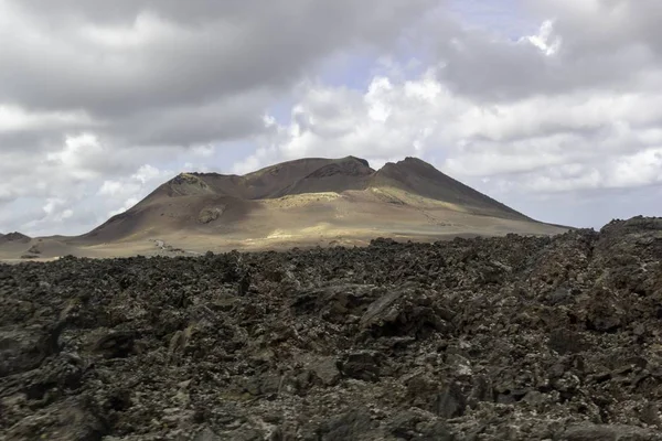 Een Landschap Van Heuvels Onder Een Bewolkte Lucht Het Timanfaya — Stockfoto