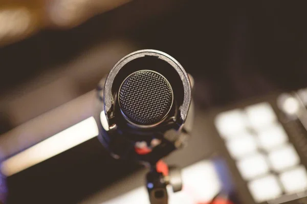 Vista angular alta de um microfone em um estúdio sob as luzes com um fundo borrado — Fotografia de Stock