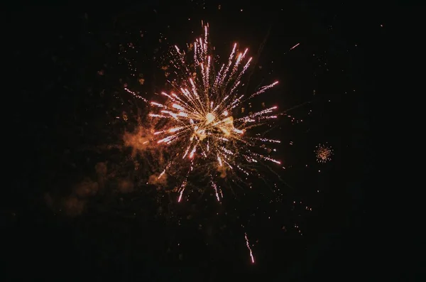 Lage hoek schot van feestelijk vuurwerk barsten in de nachtelijke hemel verspreiden van een vrolijke sfeer — Stockfoto