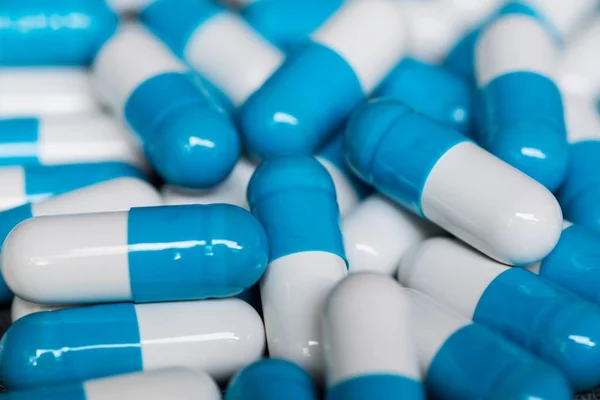 Szoros kép egy halom fehér és kék gyógyszer kapszula — Stock Fotó