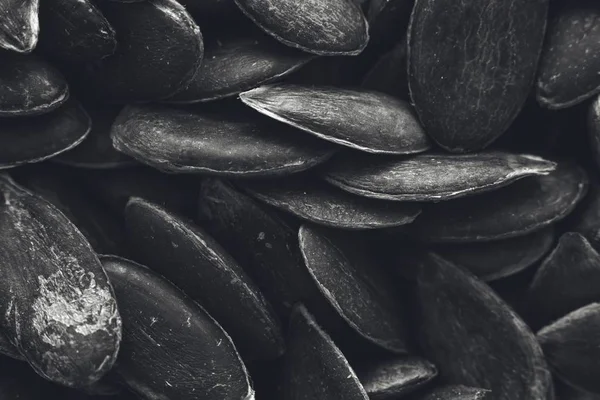 Greyscale closeup shot of a lot of pumpkin seeds - great for a black and white background — Stock Photo, Image