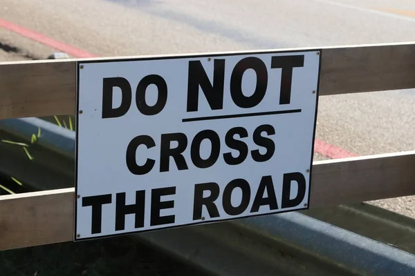 A closeup shot of a do not cross sign on a wooden fence