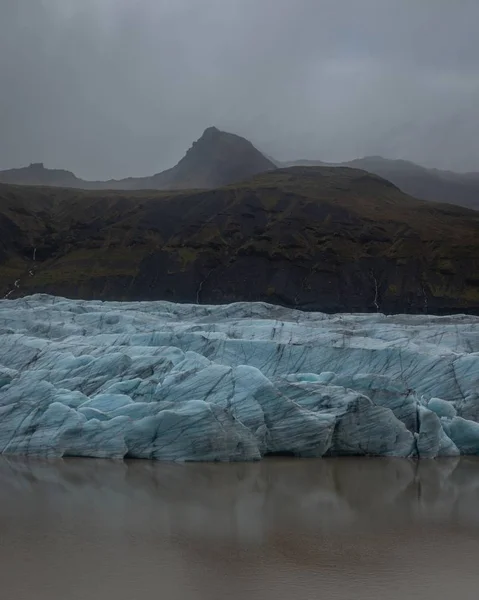 Vertical shot of glaciers Svínafell  Iceland with mountains at the backgound — Stock Photo, Image