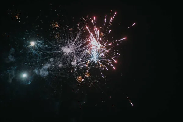 Низкоугольный снимок праздничного фейерверка, лопающегося в ночном небе, распространяющего радостную атмосферу — стоковое фото