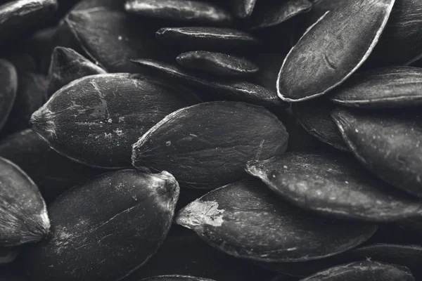 Greyscale closeup shot of a lot of pumpkin seeds - great for a black and white background — Stock Photo, Image