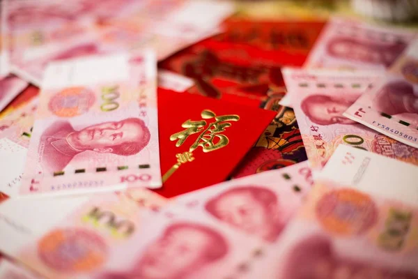 Primo piano di 100 banconote cinesi Yuan (CNY) e busta rossa tradizionale cinese — Foto Stock