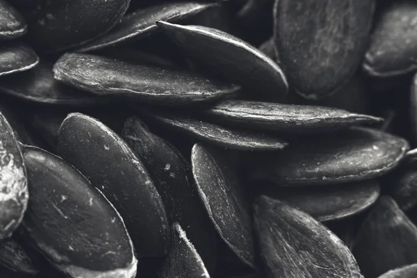 Greyscale closeup shot of a lot of pumpkin seeds - great for a black and white background — Stock Photo, Image