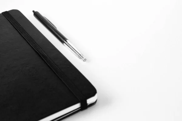 Una Toma Selectiva Bolígrafo Cerca Cuaderno Una Superficie Blanca —  Fotos de Stock