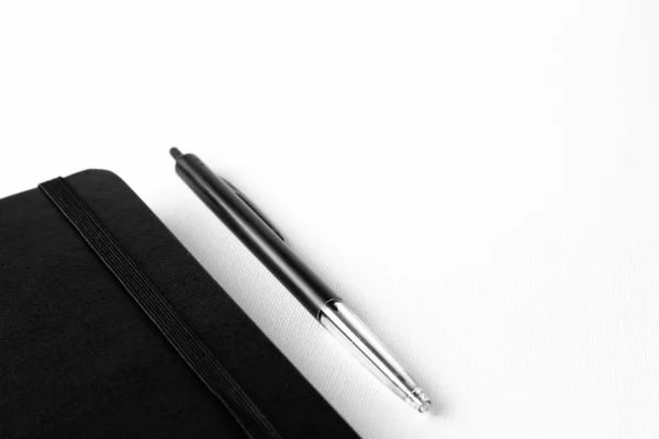 Gros Plan Stylo Près Carnet Noir Sur Une Surface Blanche — Photo