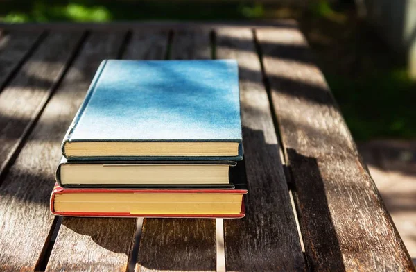 Uma Mesa Madeira Com Três Livros Cima Outro Durante Dia — Fotografia de Stock