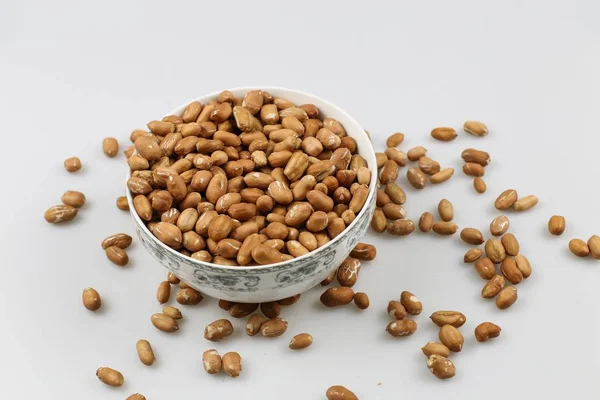 Tiro de ângulo alto de um boliche de amendoins em uma superfície branca — Fotografia de Stock