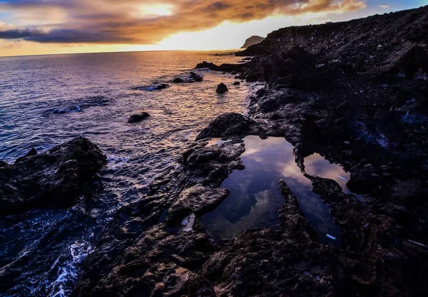 Foto de alto ángulo de costa rocosa con un amanecer en el cielo. — Foto de Stock