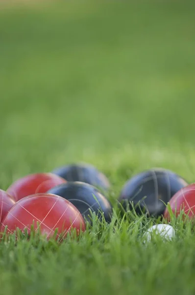 Imagem vertical de bolas coloridas bocce no relvado sob a luz do sol com um fundo borrado — Fotografia de Stock