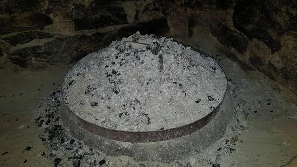 High angle shot of an elevated cooking fire pit full of ashes and charcoal — Stock Photo, Image