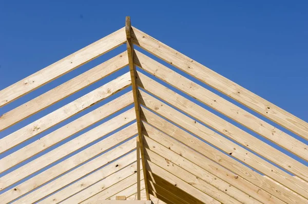 Visão de ângulo baixo de uma construção de madeira sob um céu azul e luz solar durante o dia — Fotografia de Stock