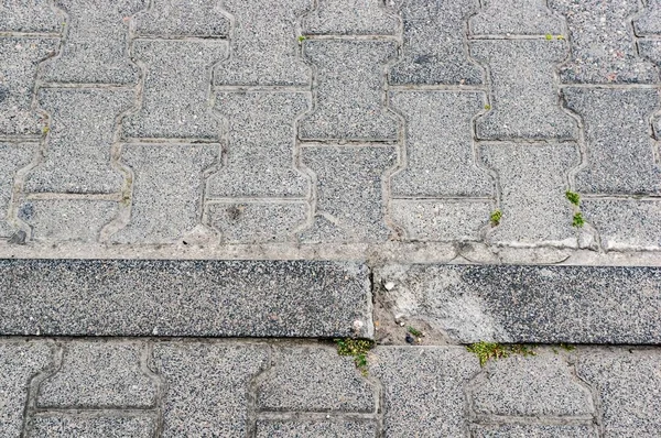 Съемка края тротуара с серыми бетонными плитками — стоковое фото