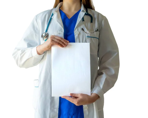 Kobieta-lekarz w niebieskim mundurze medycznym trzymająca białą kartkę z powierzchnią do kopiowania w pionie — Zdjęcie stockowe