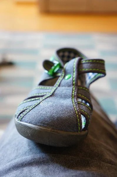 Vertikale Aufnahme einer Person, die mit ihren Schuhen auf dem Schoß sitzt — Stockfoto
