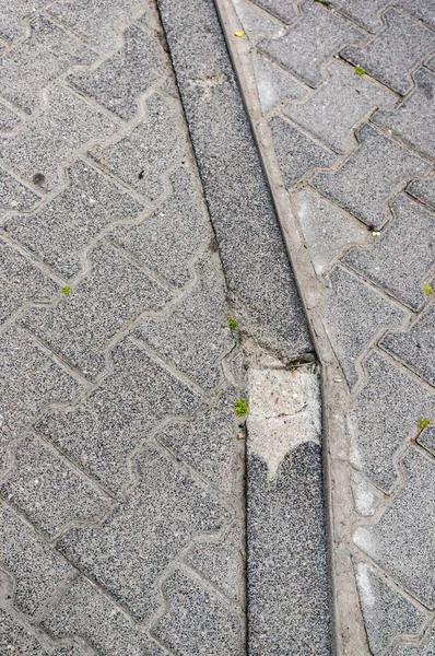 灰色のコンクリートタイルで歩道の端の垂直閉鎖ショット — ストック写真