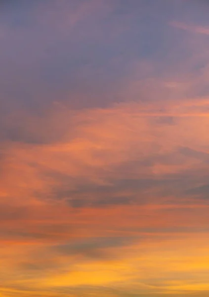 Vertikale Aufnahme orangefarbener Wolken mit einer Landschaft des Sonnenaufgangs — Stockfoto